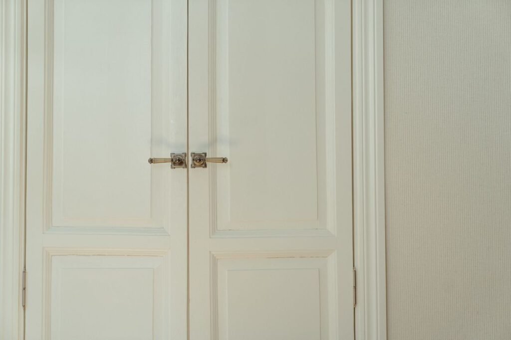 Elegant white double doors with locks, offering a stylish and secure home interior solution.